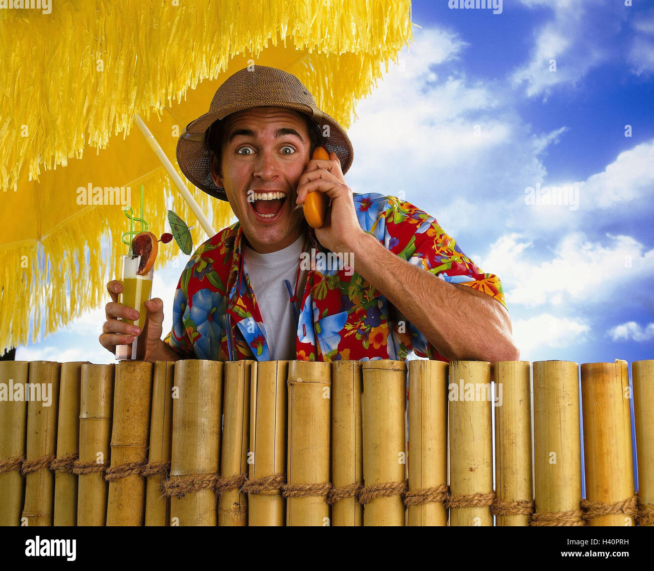 Clôture, parasol, homme, chapeau de paille, chemise Hawaï, appeler, jouer  du visage, de la joie, un cocktail maison de vacances, vacances, vacancier,  touriste, alcool, téléphone portable, téléphone mobile, communication,  appel téléphonique, heureux,