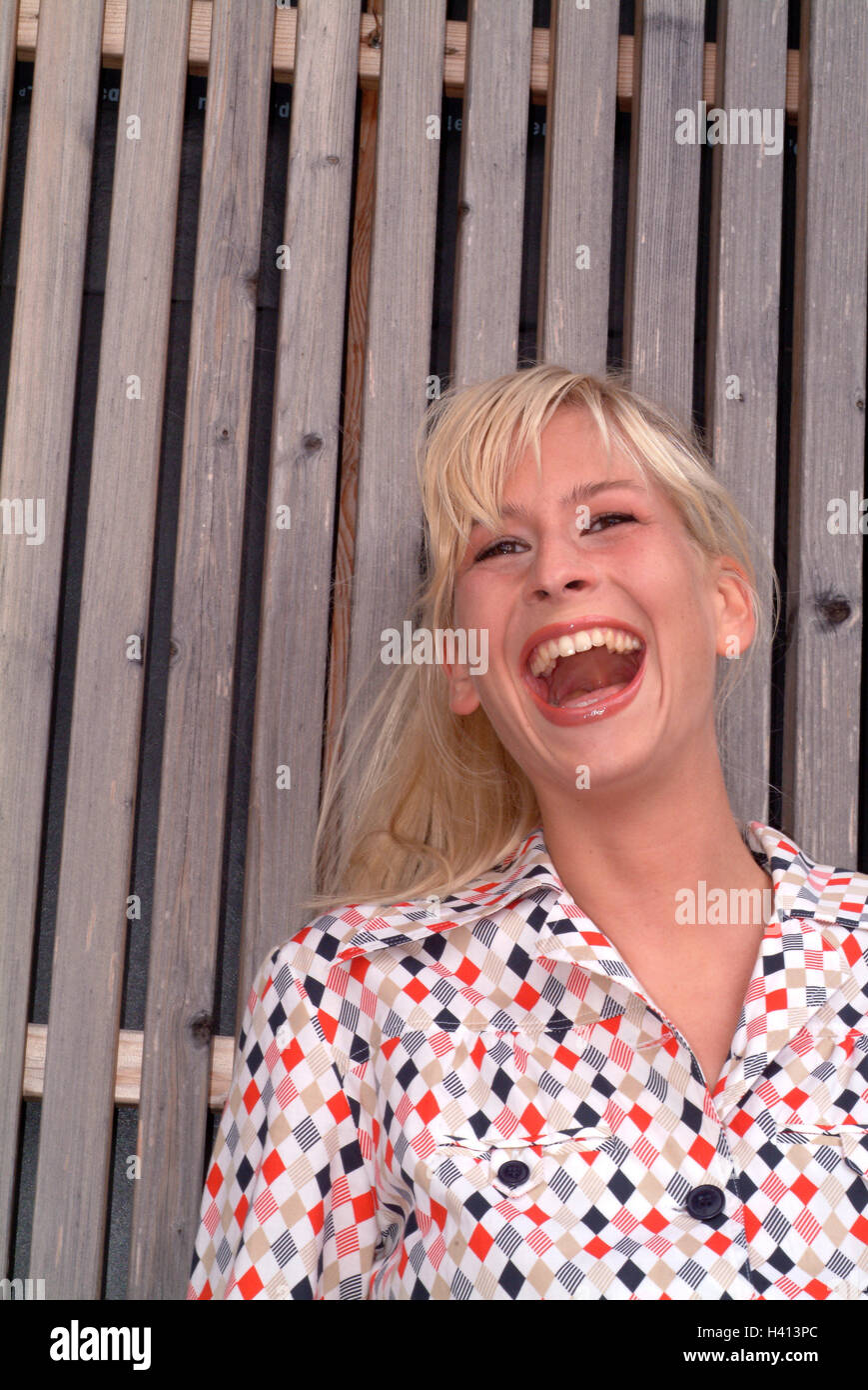 Mur de bois, femme, jeune, rire, portrait, 20, 25 ans, 25, 30 ans, de 20 à 30 ans, blonde, poil long, de convivialité, de bonheur, de bon cœur, d'expression, de naturel, de vêtements, Retrostil, Retrolook, rétro, blouse, rayonnement, l'humeur positive, Banque D'Images