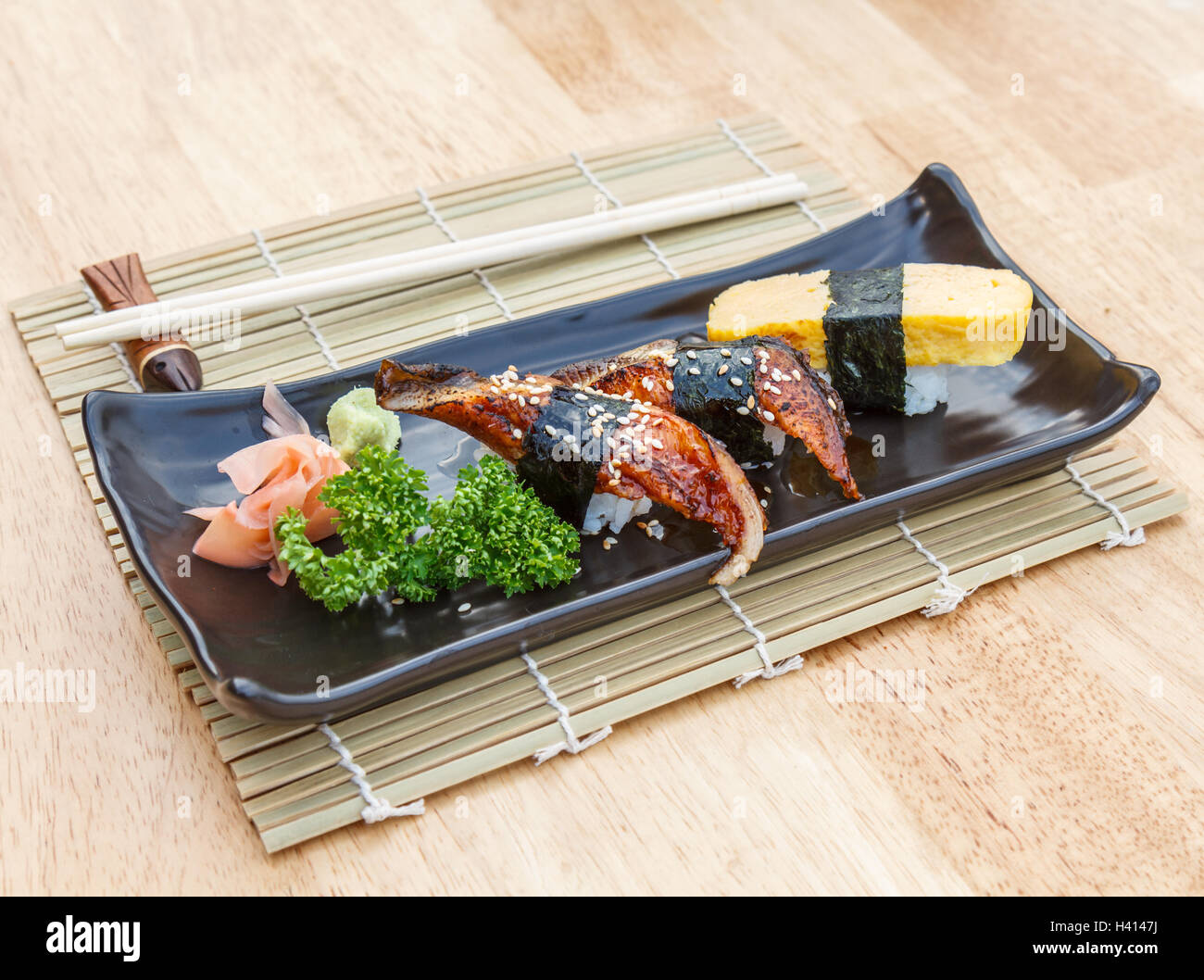 La nourriture japonaise Unagi Sushi et Sushi œuf sucré dans la plaque noire sur la table en bois. Banque D'Images