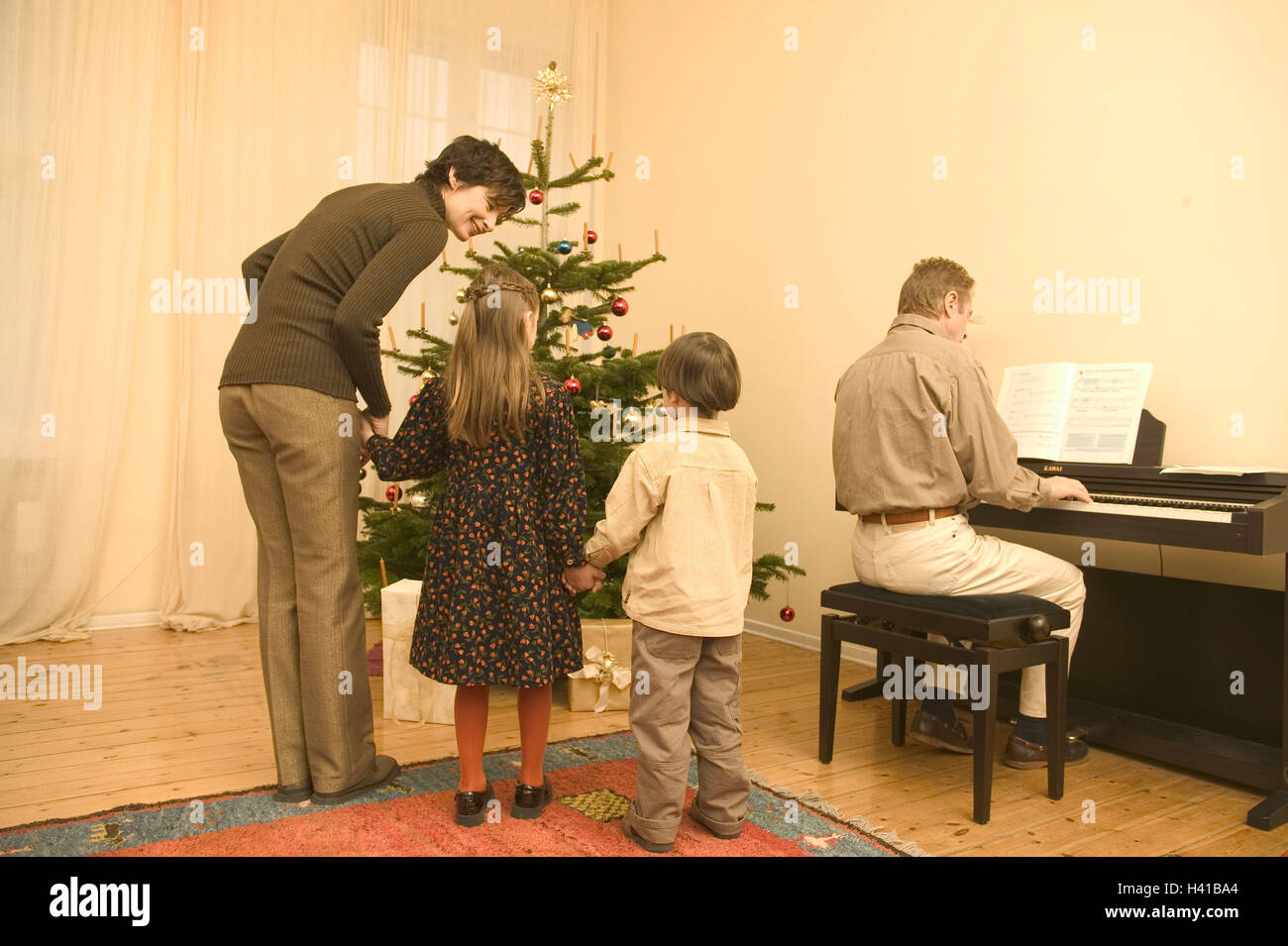 Noël, salons, arbre de Noël, distribution de cadeaux, l'écrou, enfants, main dans la main, le père, le piano joue, vue de dos la veille de Noël, la veille de Noël, Noël, arbre de Noël, les parents, de 40 à 50 ans, les filles, filiale, 8 ans, garçon, fils, 5 ans, homme, instrument de musique, Musique, piano à playings, faire de la musique, audition, la tradition, les traditions, la famille, la vie de famille, la chance, la cohésion, l'unité, l'harmonie, la chance, l'amour, l'humeur positive, prejoy, attendez, heureux, à la maison Banque D'Images