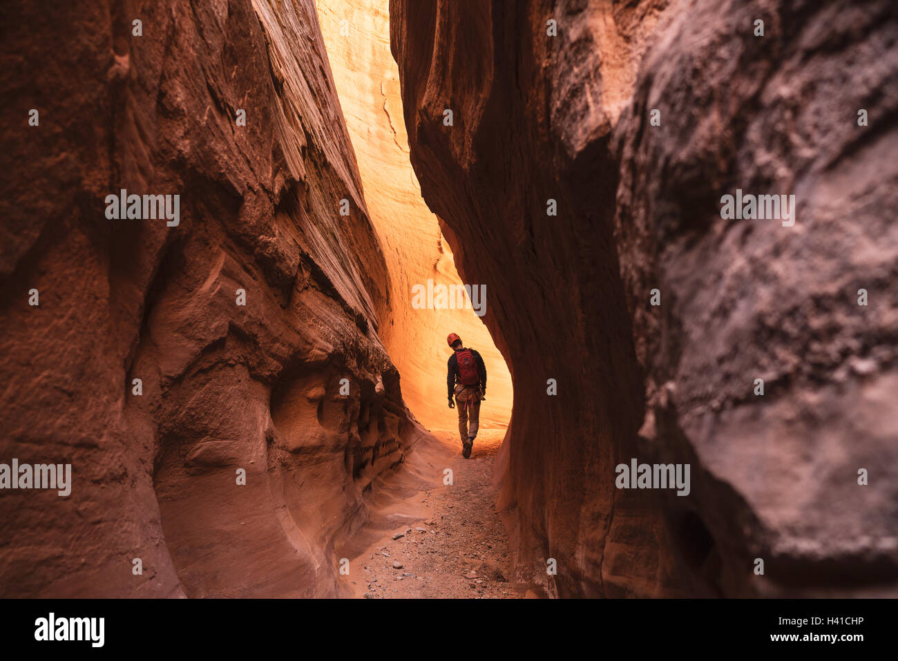 Un homme canyoneers à travers une fente rouge canyon dans le sud de l'Utah Banque D'Images