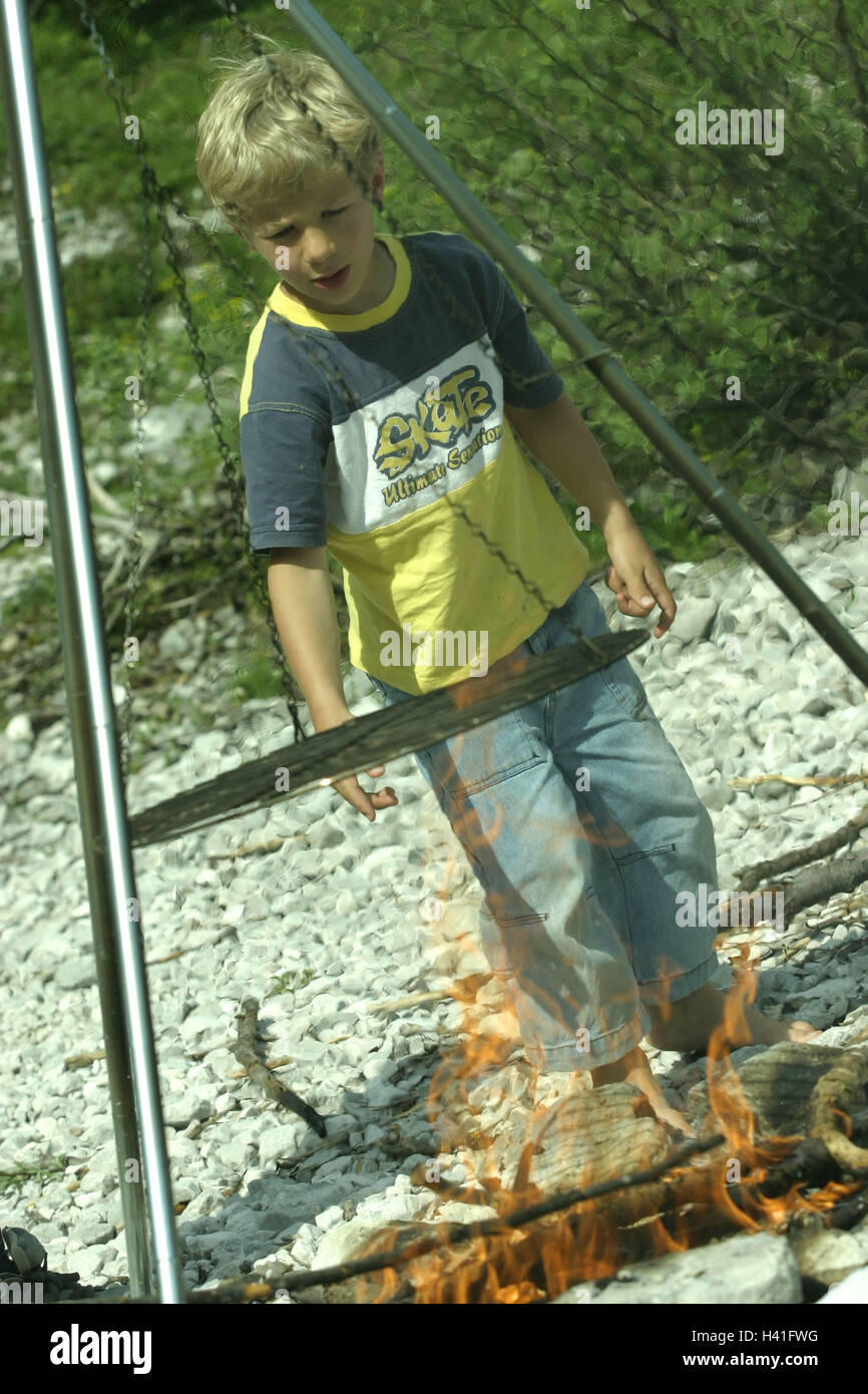 Riverbed, gravier, garçon, feu de camp, gril rouille sur enfant, sur 5 ans, de l'enfance, de l'extérieur, de plaisir, d'aventure, d'expérience, d'incendie, en bois, en bois de feu, ajouter, de brûlures, d'avoir d'un barbecue, grill, seulement, danger, dangereusement, sans surveillance, Summers, à l'extérieur Banque D'Images