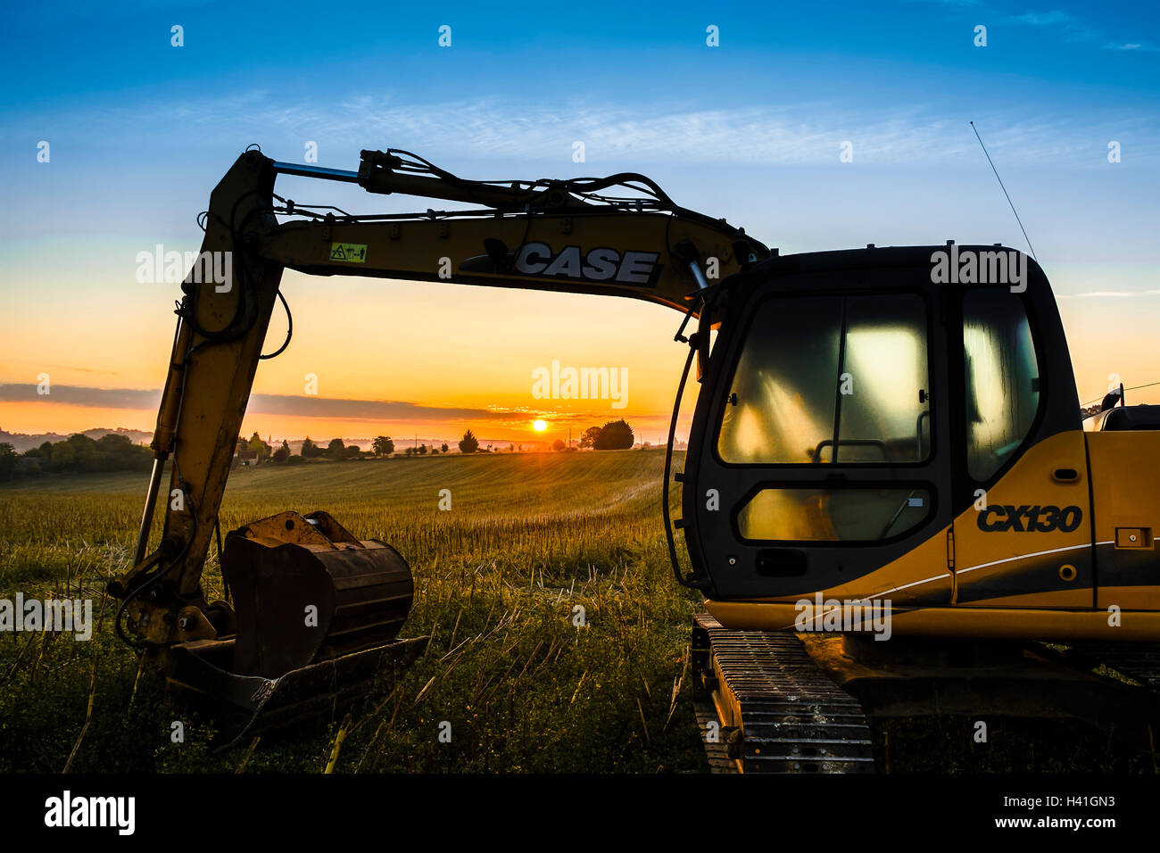 Cas mechanical digger excavator au lever du soleil - France. Banque D'Images