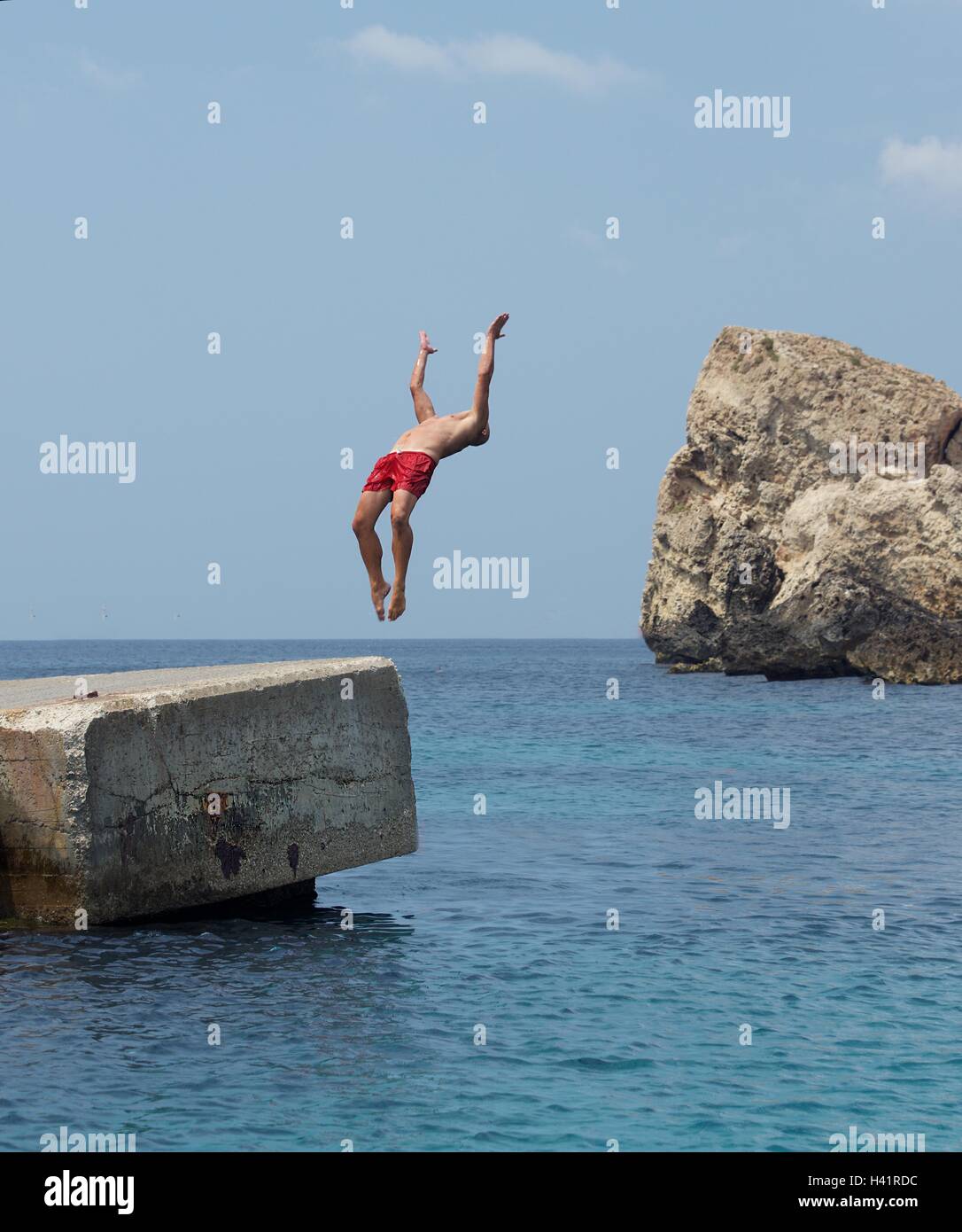 L'homme faisant un saut périlleux arrière dans l'océan, Malte Banque D'Images