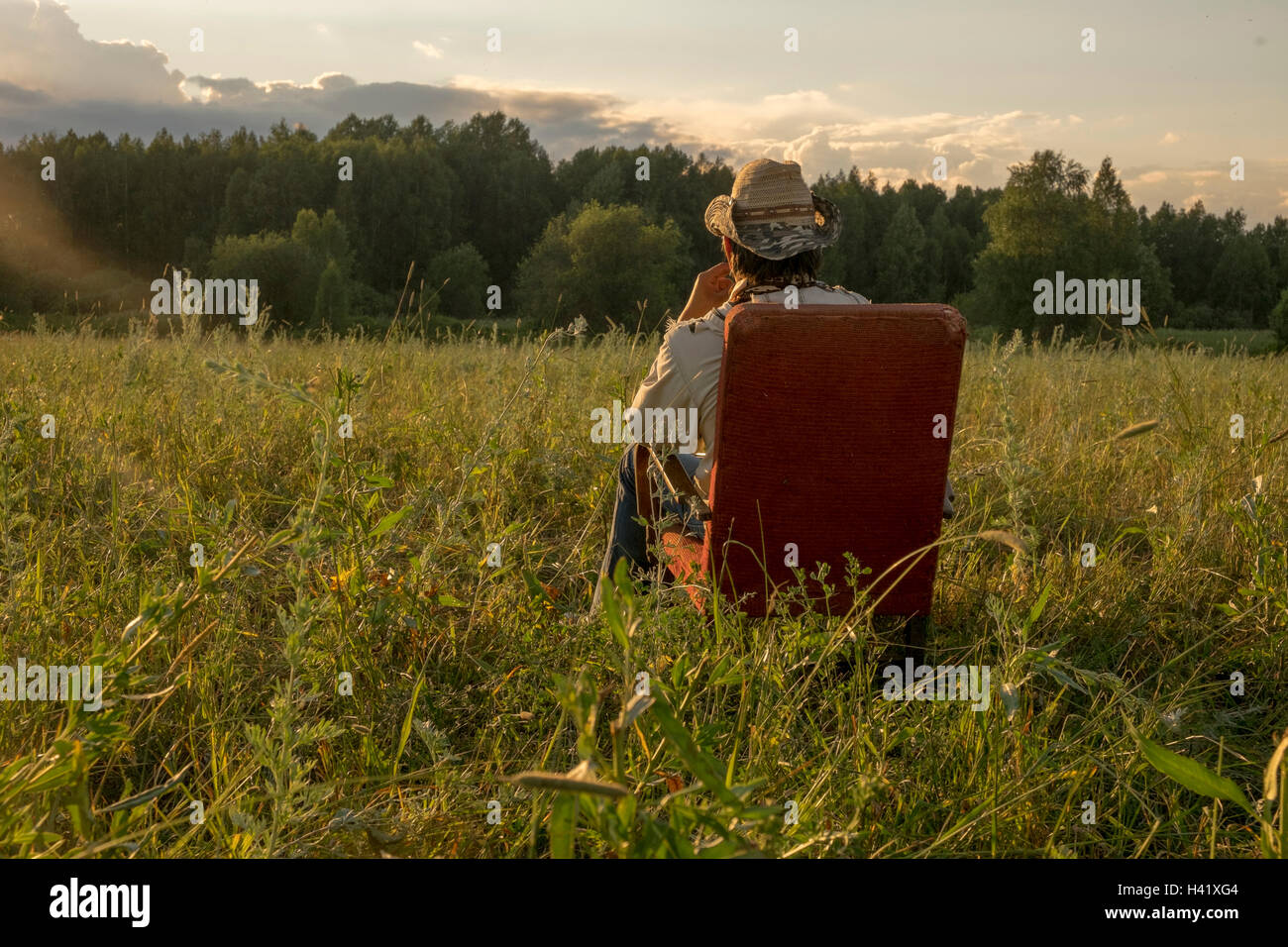Mari man sitting on chair in field Banque D'Images