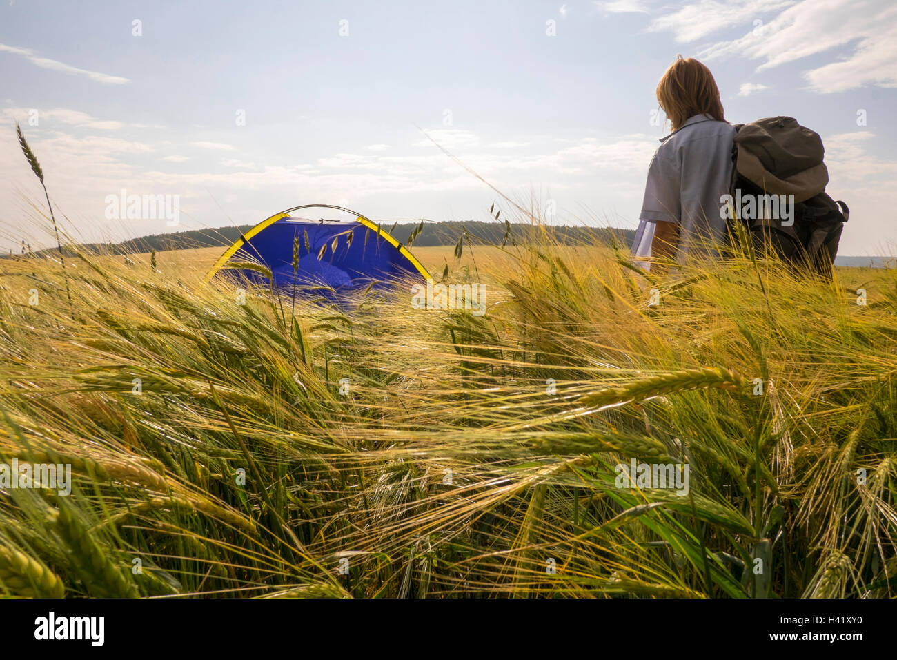 Caucasian woman standing in field near tente de camping Banque D'Images