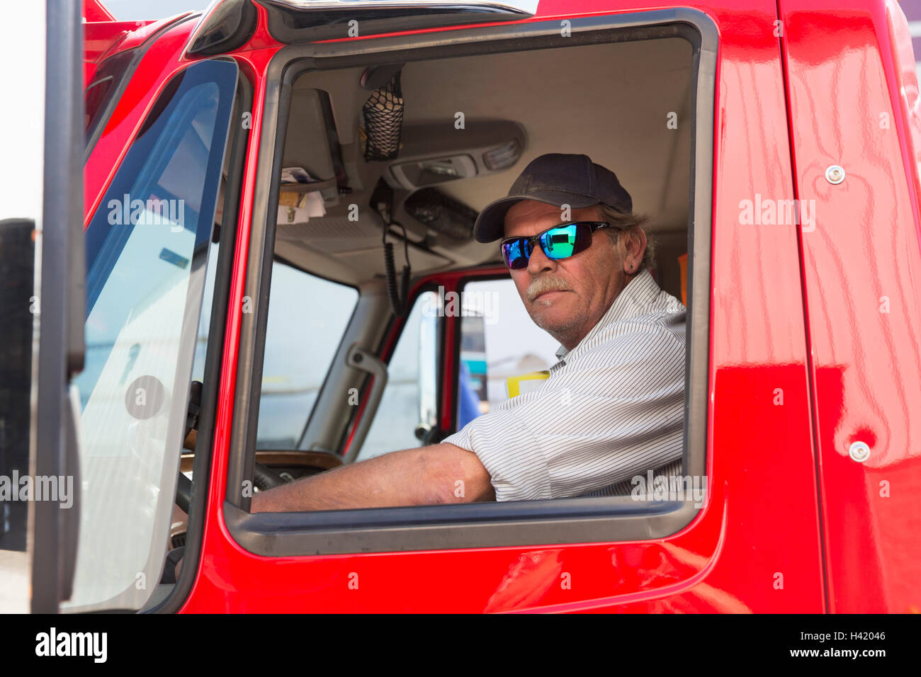 Portrait grave semi-truck driver portant des lunettes de soleil Banque D'Images