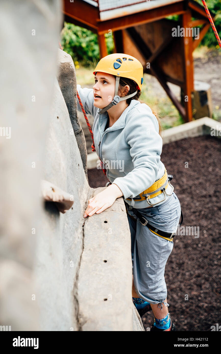 Caucasian woman climbing rock climbing wall Banque D'Images