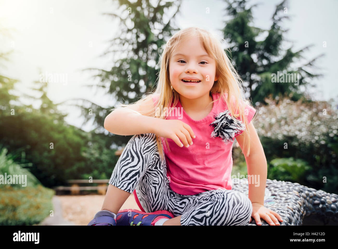 Smiling Mixed Race girl sitting on bench Banque D'Images