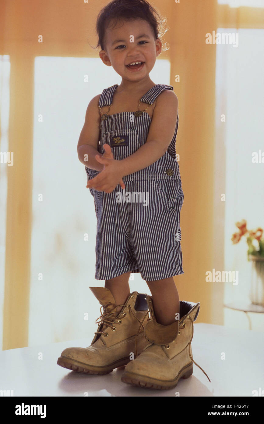 Garçon, 2 ans, bretelles, chaussures, surdimensionné, rire, voir l'enfant,  l'appareil photo, petit stand à l'intérieur, tableau, chaussures pour  adultes, Schnürschuhe, heureux, fun, jeu, l'enfance, l'innocence, de  naturel, de joie Photo Stock -