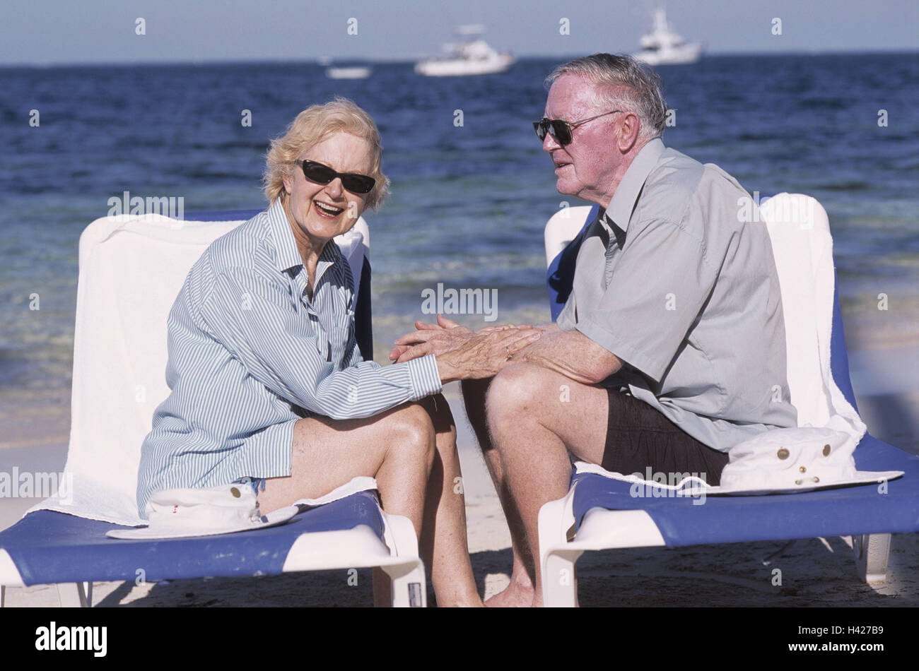 Couple, vacances, mer, plage, chaises longues, touch, la chance, la tendresse couple, les personnes âgées, les retraités, couple de retraités, de 70 à 80 ans, des lunettes, de l'âge de la retraite, l'été, heureux, affectueusement, affectueusement, touch, les AVC, le rire, l'attraction, jo Banque D'Images