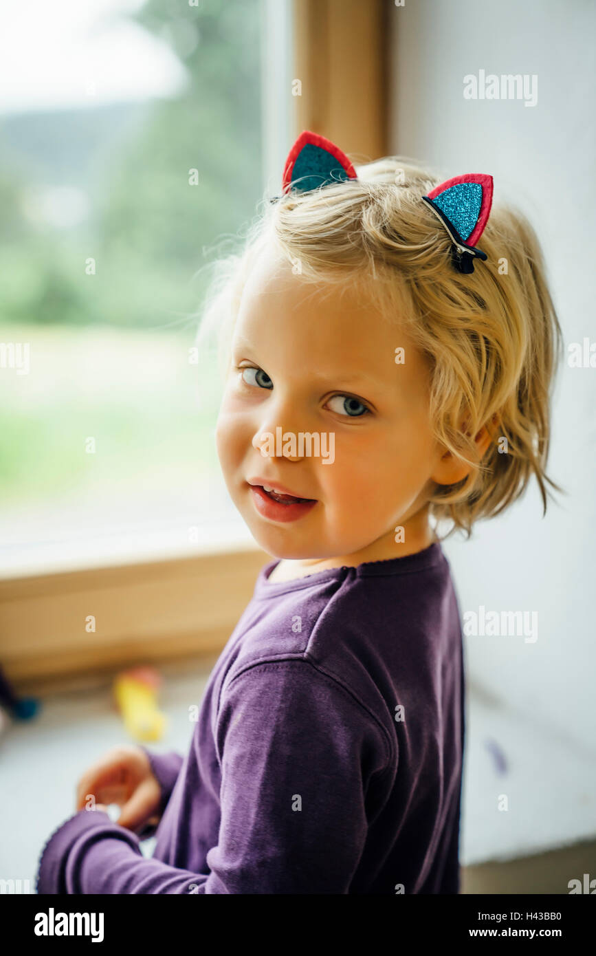 Smiling Caucasian girl portant des oreilles de chat Banque D'Images