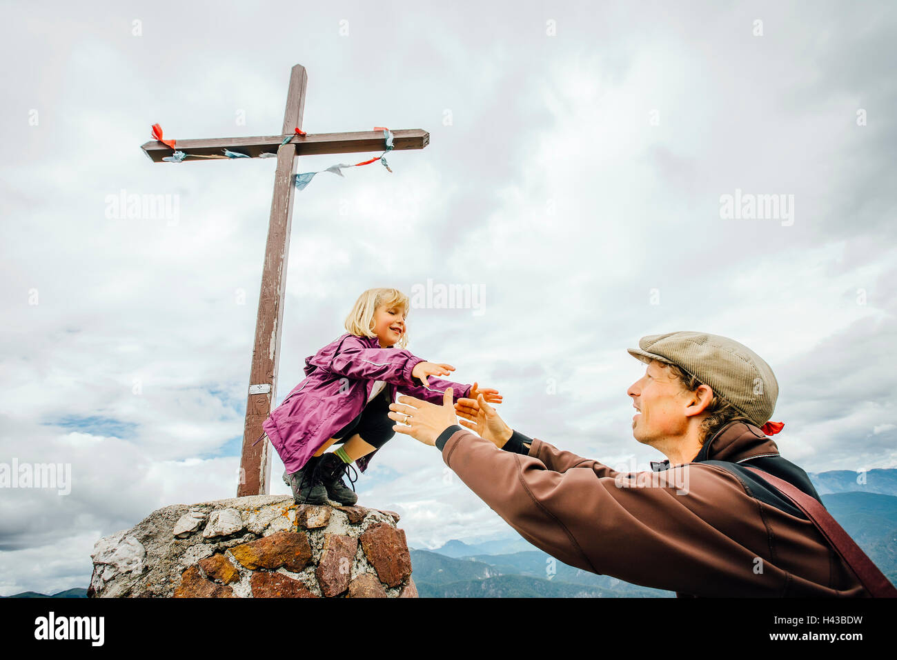 Caucasian father helping daughter on rock at crucifix Banque D'Images