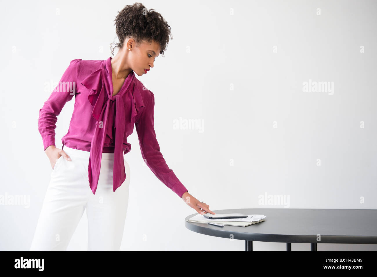Black woman wearing purple blouse contrôle digital tablet Banque D'Images