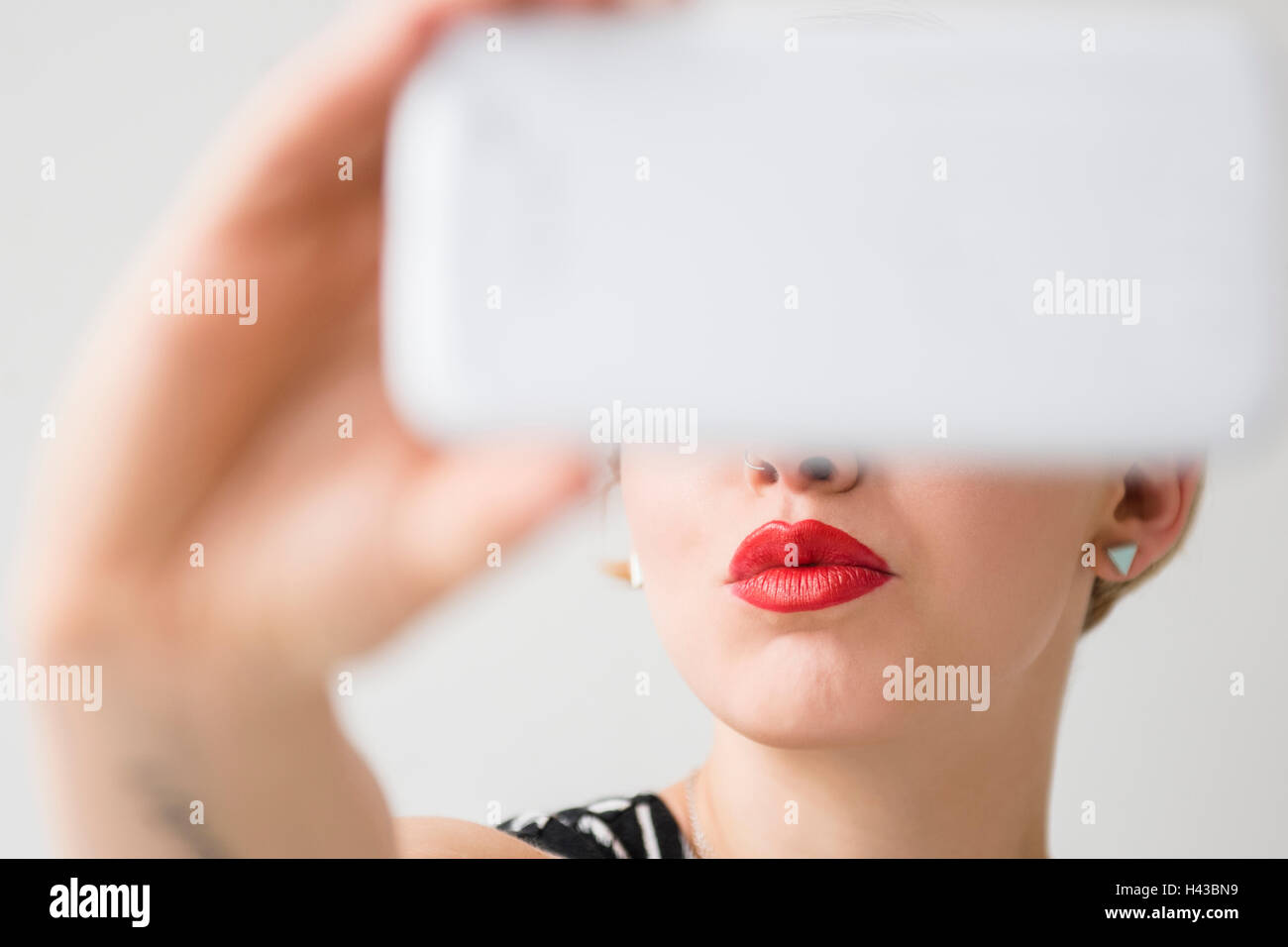 Les lèvres rouges de la femme qui pose pour selfies téléphone cellulaire Banque D'Images