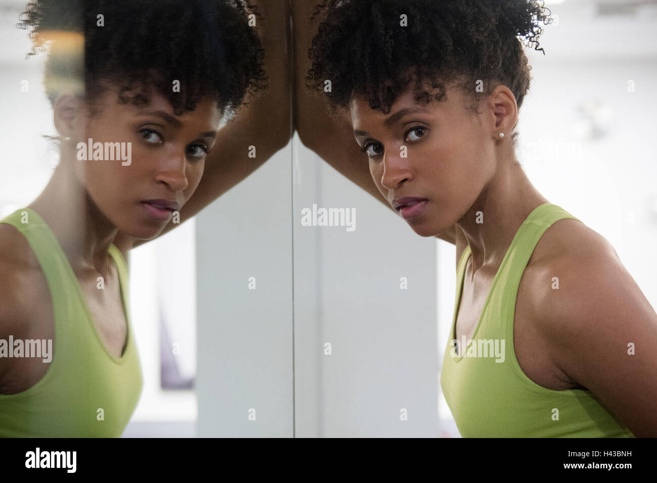 Black grave woman leaning on mur miroir Banque D'Images