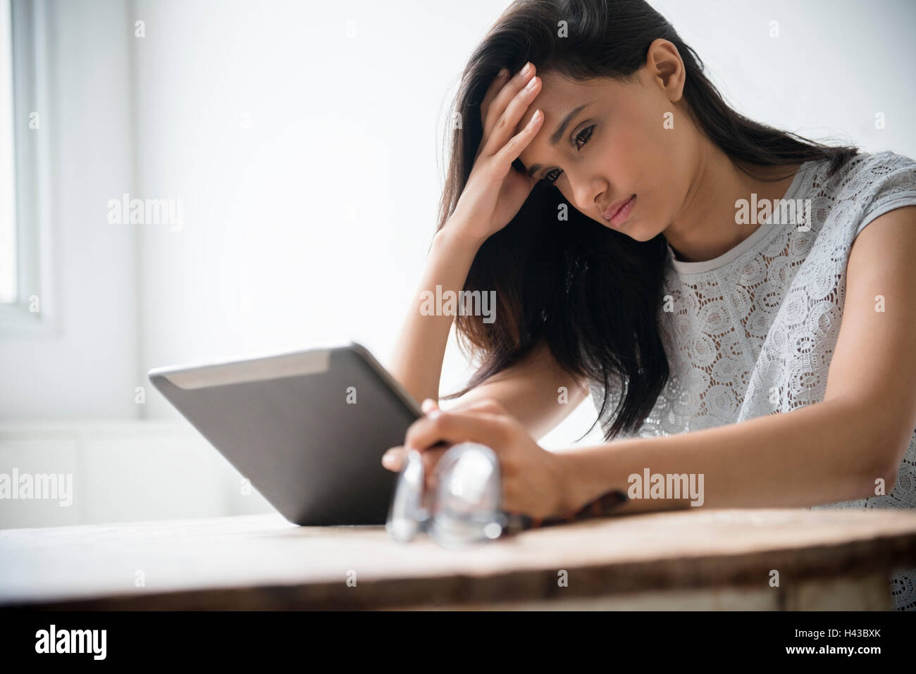 Mixed Race woman avec maux using digital tablet Banque D'Images