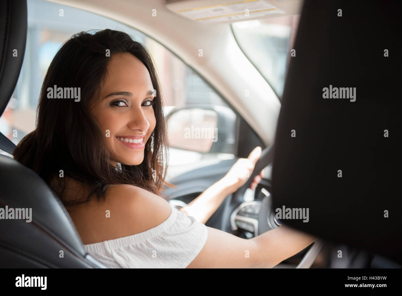 Smiling Mixed Race woman driving car Banque D'Images