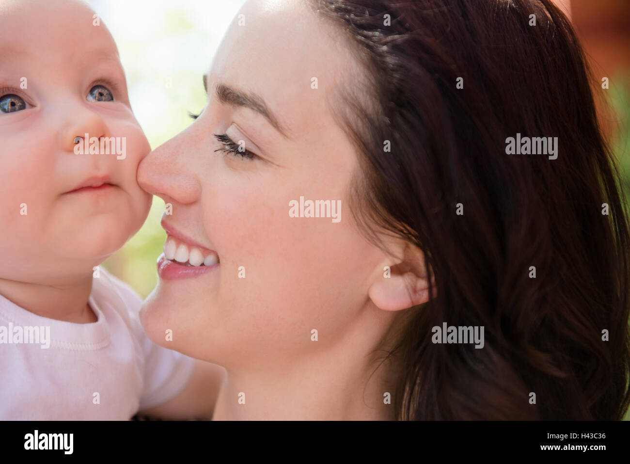 Mère de race blanche se frottant le nez sur la joue de son bébé Banque D'Images