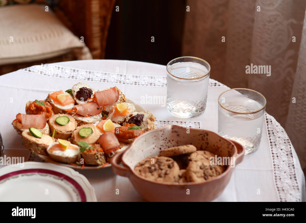 Close up d'apéritifs, biscuits et deux verres d'eau sur une table Banque D'Images
