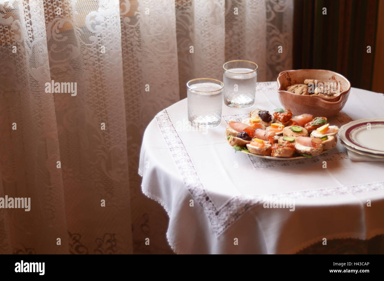 Close up d'apéritifs, biscuits et deux verres d'eau sur une table Banque D'Images