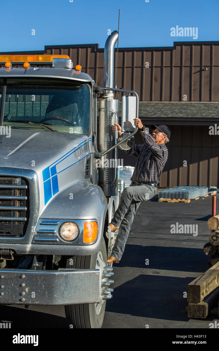 Caucasian man climbing en semi-truck Banque D'Images