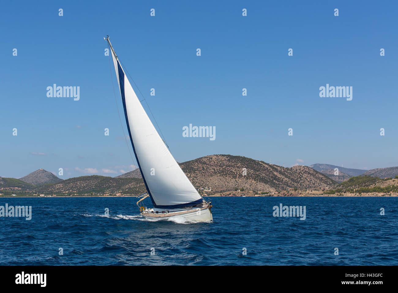 Yacht de luxe avec voiles blanches dans la mer Egée à proximité des côtes des îles grecques. Banque D'Images