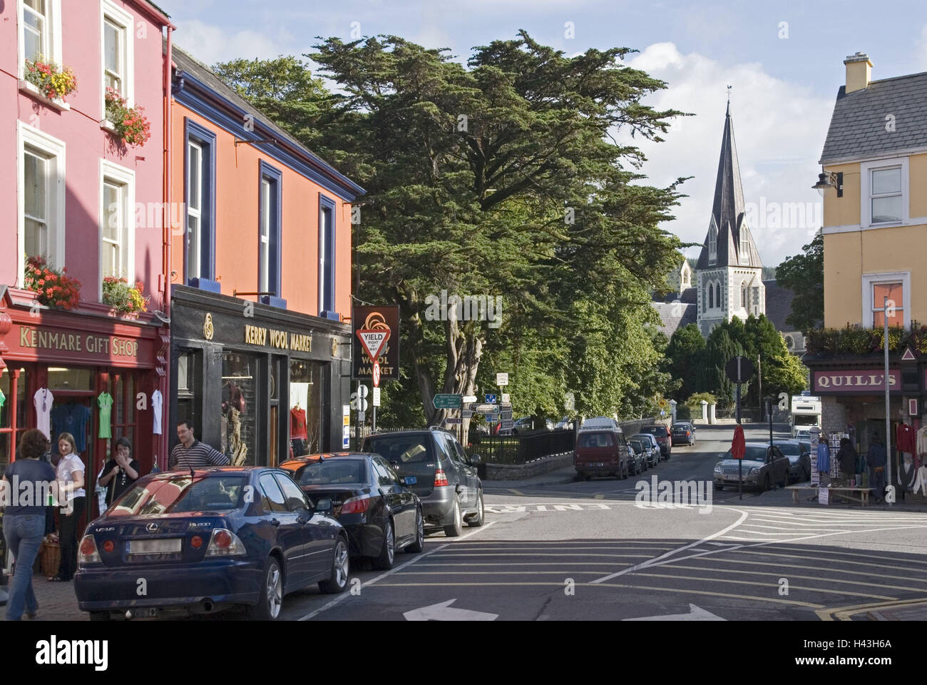 L'Irlande, Munster, Kerry, Kenmare, 'Henry Street', magasins, maisons, pleines de couleurs, de l'église, vue sur ville, lieu, bâtiment, architecture, street, façades, terrasse, les voitures, les passants, les gens, clocher, la foi, la religion, le christianisme, Banque D'Images