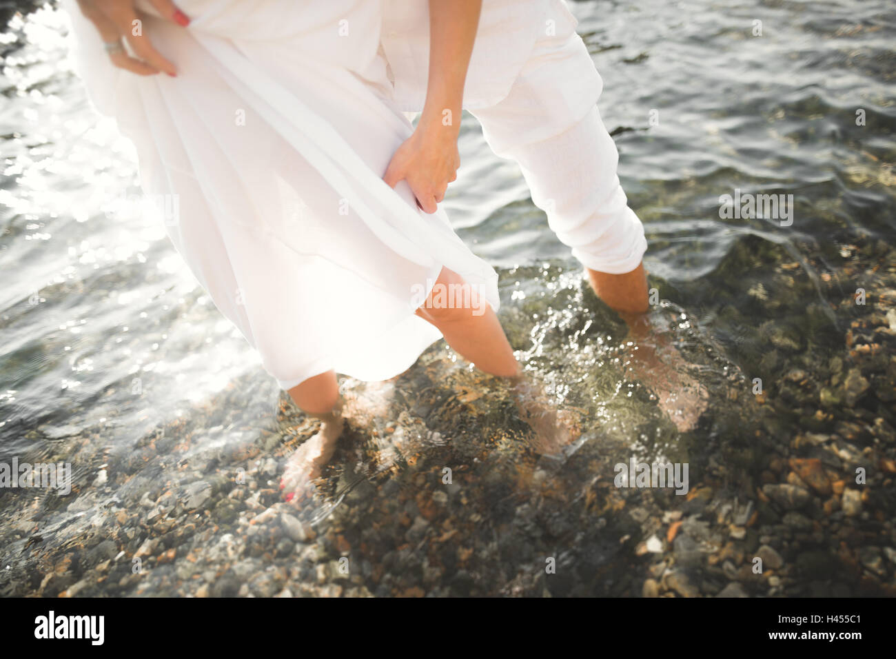 Amour romantique couple posing sur des pierres près de mer, ciel bleu Banque D'Images