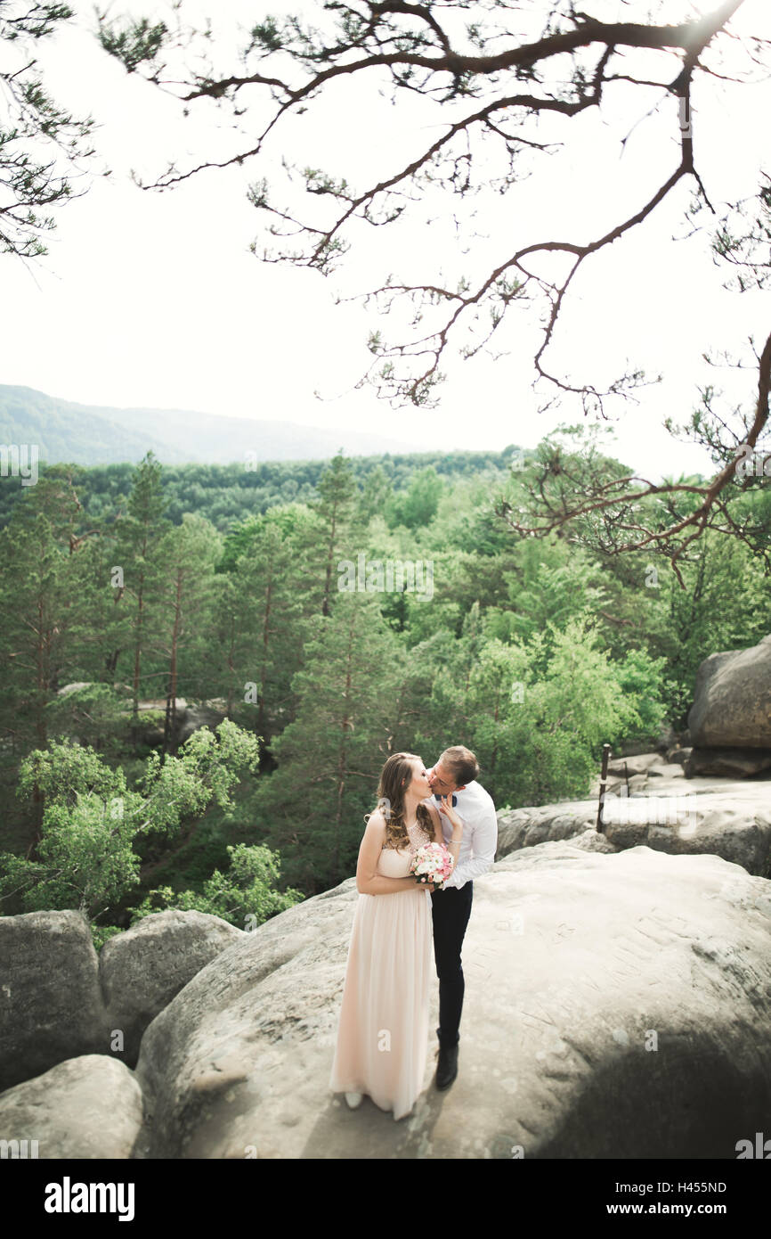 Wedding couple amoureux s'embrasser et s'étreindre à proximité de rochers sur beau paysage Banque D'Images