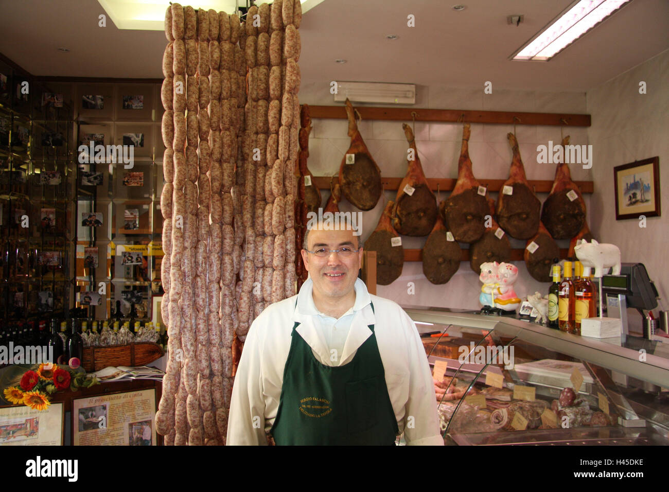 Italie, Toscane, San Miniato, boucherie, vendeur, demi-portrait, le modèle ne libération, ville, destination, affaires, chargement, spécialités, saucisses, jambon, jambon, saucisses, charcuterie croupes, boucher, personne, homme, lunettes, sourire, sympathique, à l'intérieur, Banque D'Images