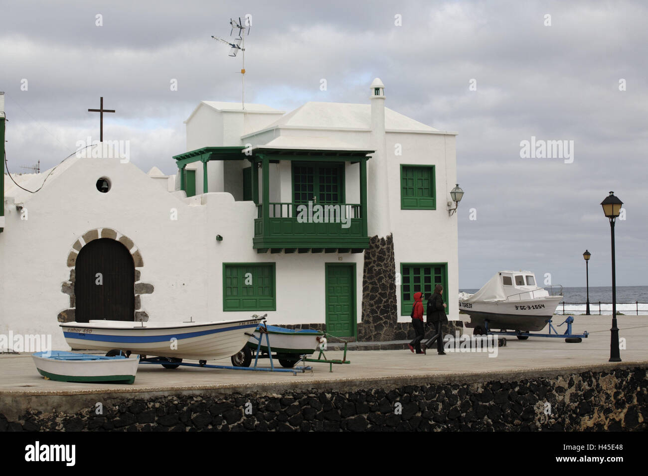 L'Espagne, les Canaries, l'île de Lanzarote, La Caleta de Famara, port, chambre, la destination, l'île volcan, lieu, bâtiment, architecture, église, croix, bande, des navires, des bottes, des gens, des passants, à l'extérieur, Banque D'Images