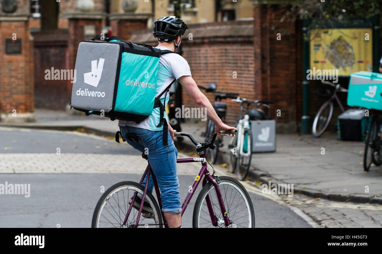 Un deliveroo cycliste de la nourriture chaude de plus en plus populaires et la restauration rapide de l'entreprise de livraison à vélo à travers les rues de la ville. Banque D'Images