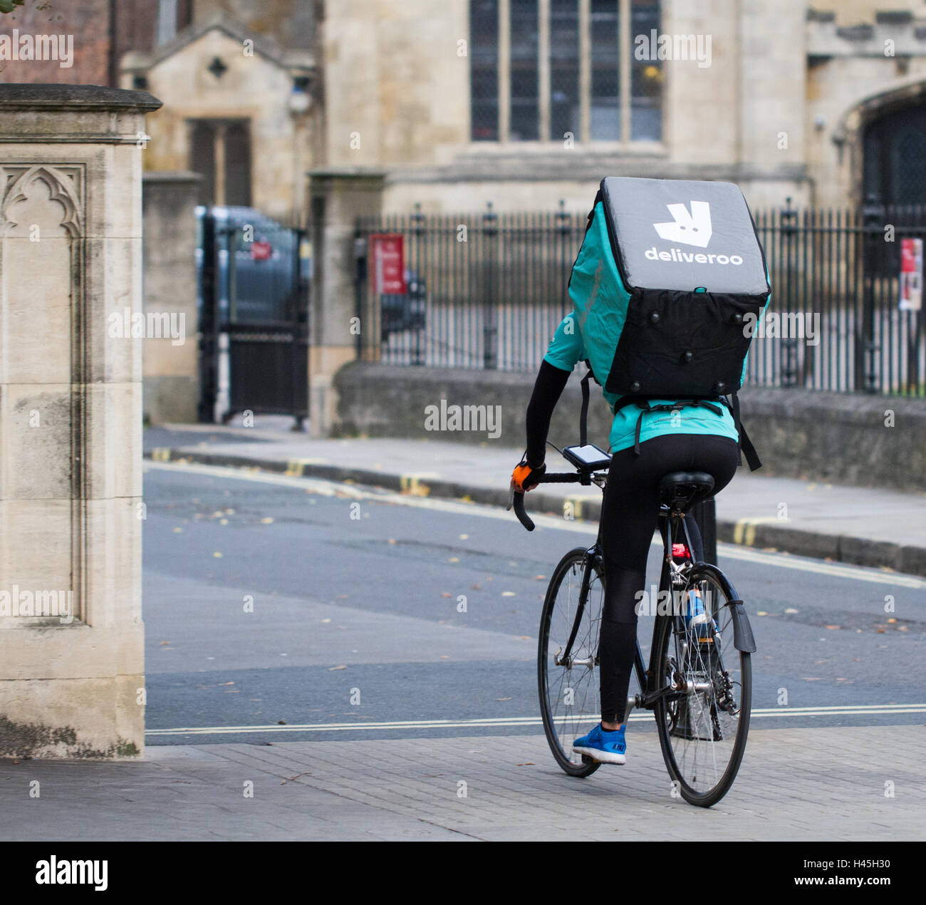 Un deliveroo cycliste de la nourriture chaude de plus en plus populaires et la restauration rapide de l'entreprise de livraison à vélo à travers les rues de la ville. Banque D'Images