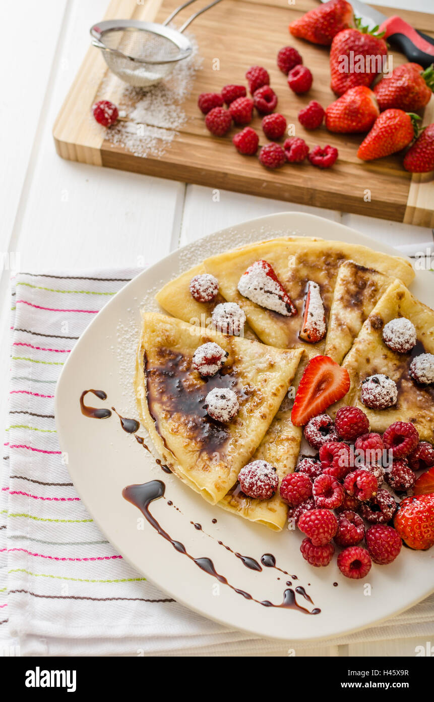 Des crêpes faites maison avec la réduction de vinaigre balsamique et de fruits frais, fraises et framboises Banque D'Images