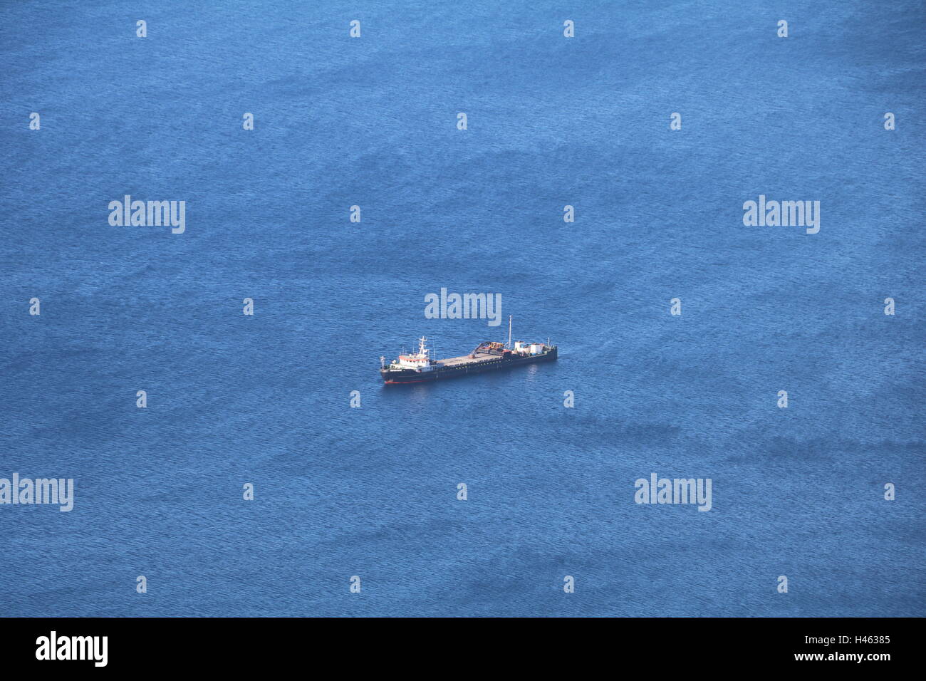 Navire dans les eaux majestueuses denim veloutée à Santorin, Grèce Banque D'Images