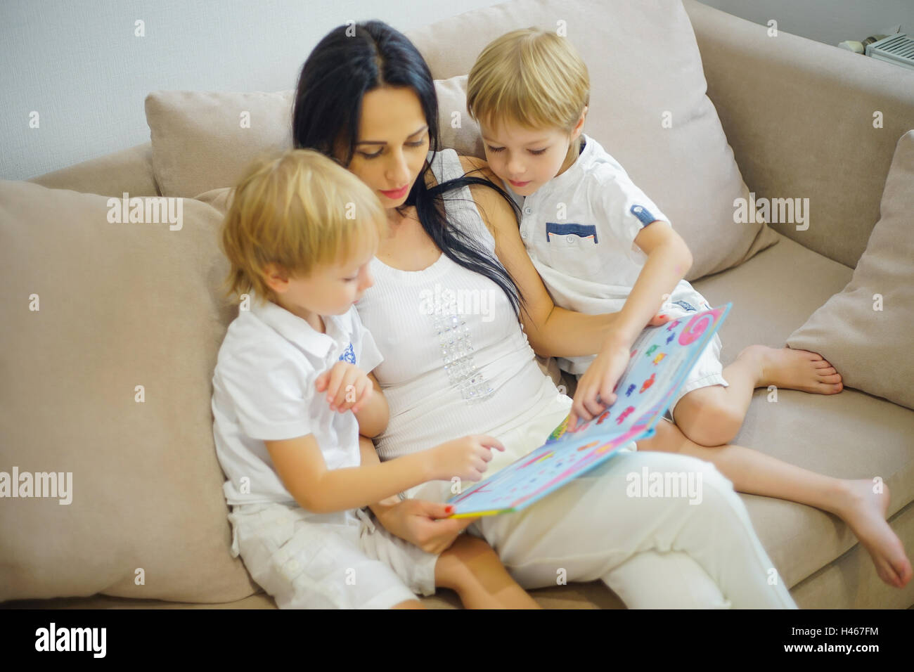 Mère de famille heureuse et ses fils la lecture d'un livre Banque D'Images