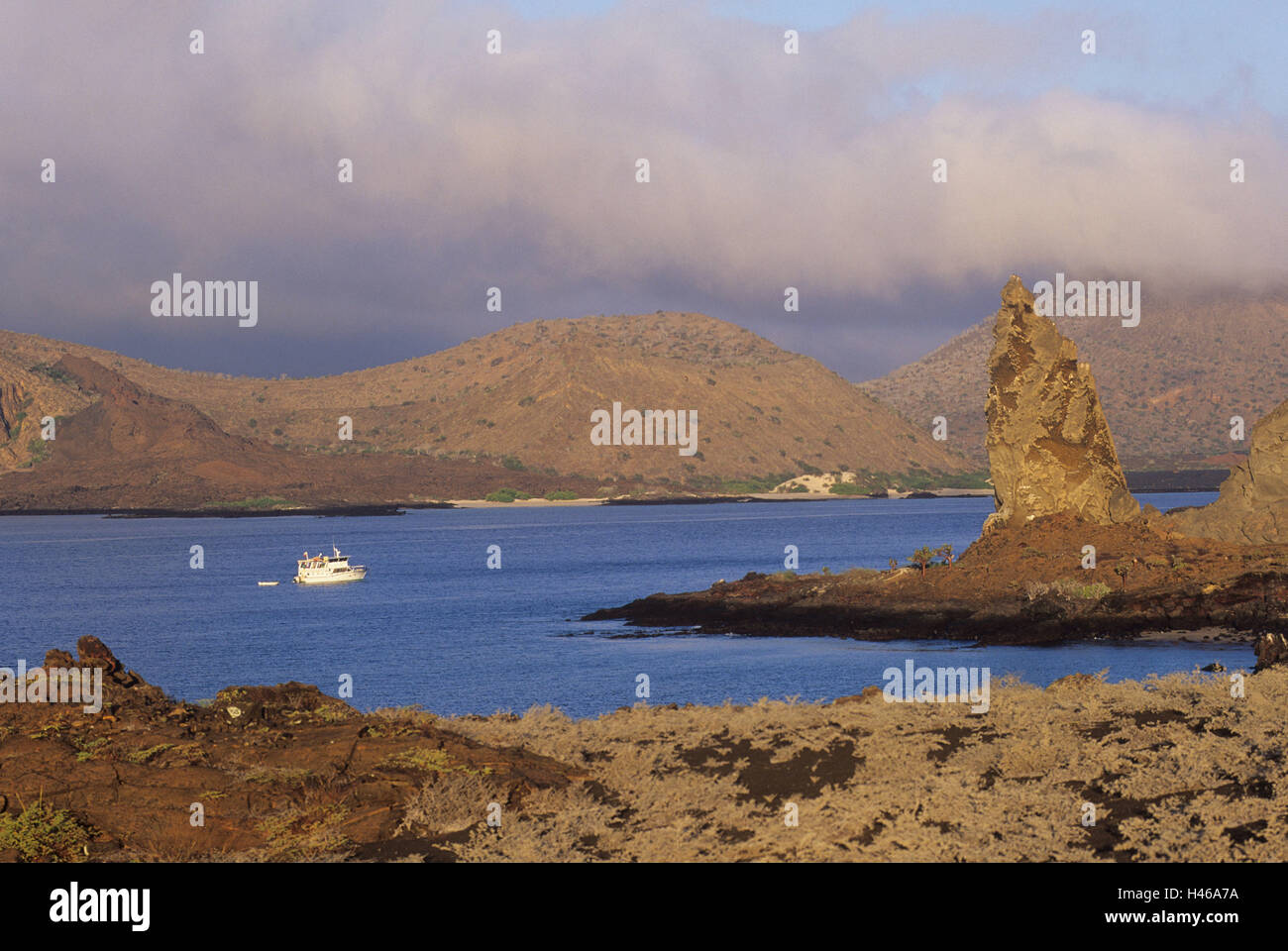 Les îles Galapagos, l'île Bartolome, Bartholomew, Pinnacle rock, Bay, navire, patrimoine mondial de l'UNESCO, l'Amérique du Sud, île, île de l'état, de l'Équateur, réserve naturelle, nature, rock, côte, côte de la bile, bile, brown, formation cloudies, bateau de pêche, Banque D'Images