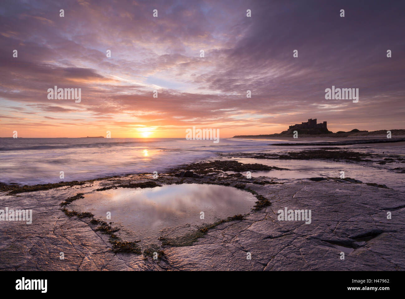 Piscine en forme de cœur sur la plage de Bamburgh au lever du soleil, Northumberland, Angleterre. Printemps (mars) 2015. Banque D'Images