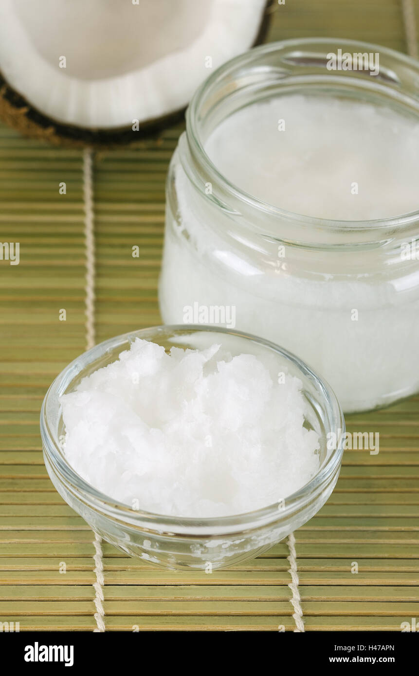 L'huile de noix de coco dans les verres sur le tapis de bambou vertical. Extra vierge biologique huile de coprah. L'huile comestible, extrait de viande de coco. Banque D'Images