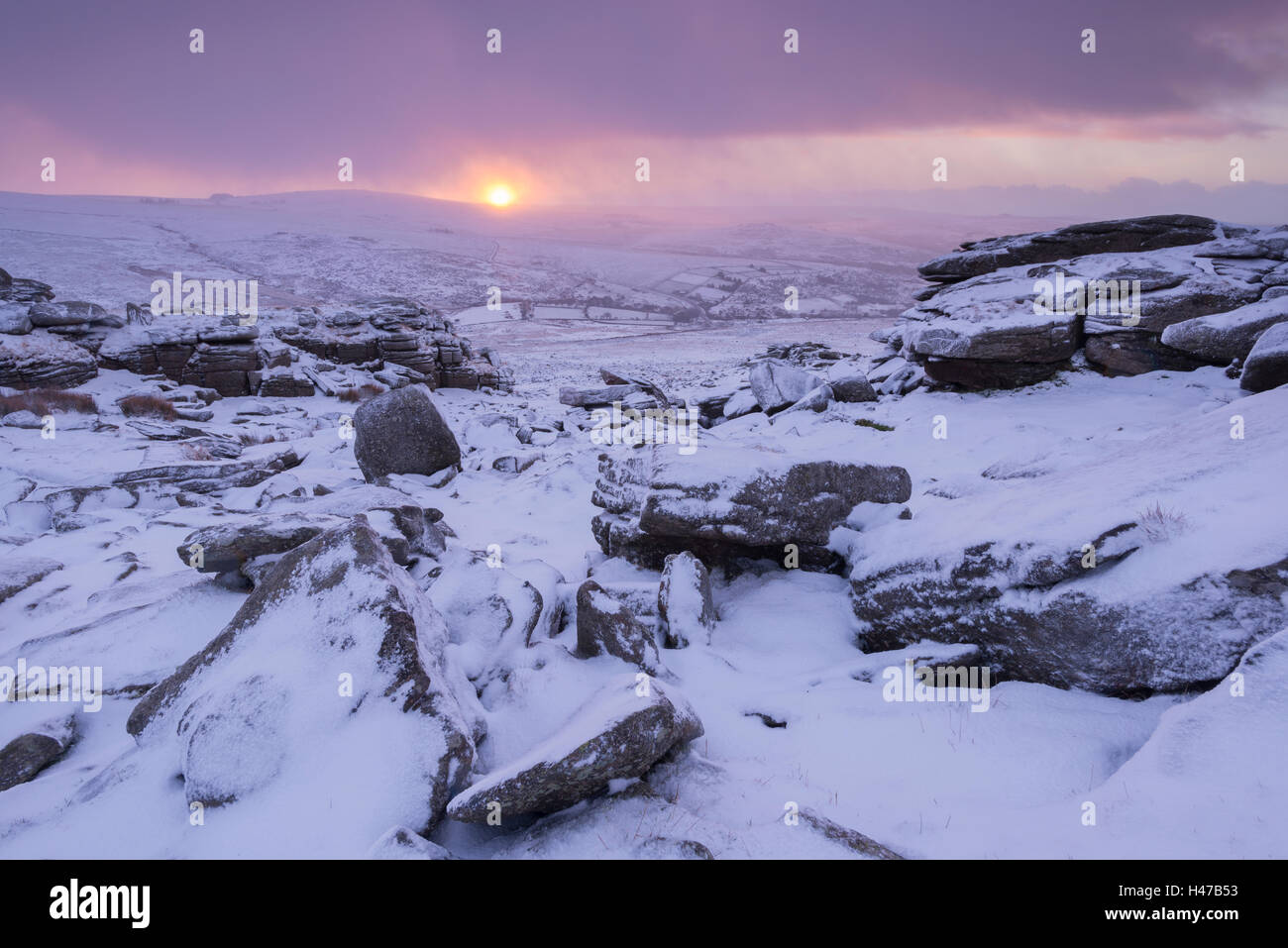 Lever du soleil d'hiver sur une lande couverte de neige, Grand Tor discontinues, Dartmoor, dans le Devon, Angleterre. L'hiver (Janvier) 2015. Banque D'Images