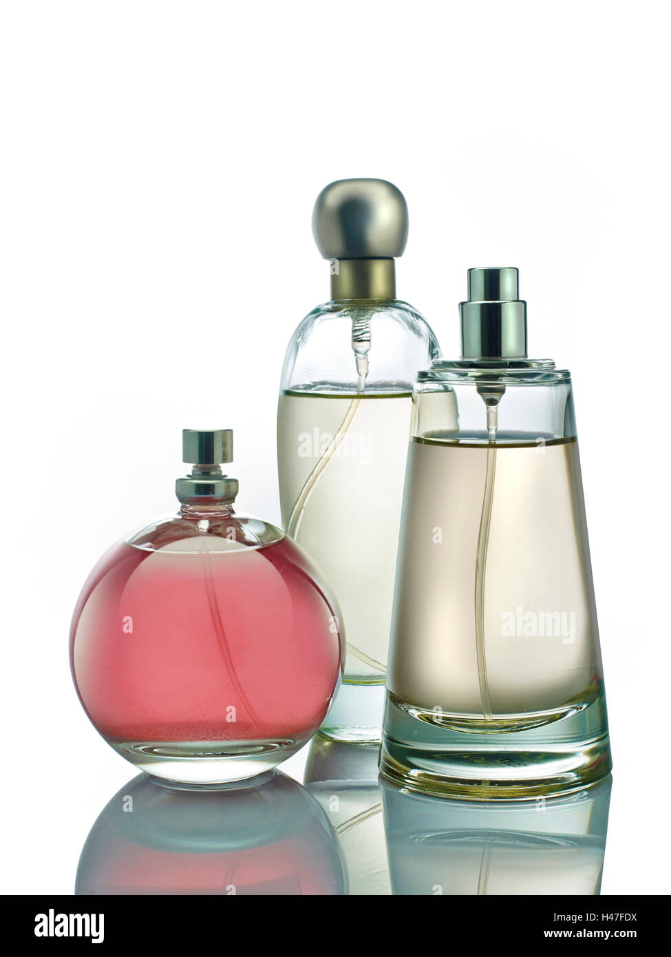 Flacons à parfum coloré photographiés sur fond blanc pur avec réflexion Banque D'Images