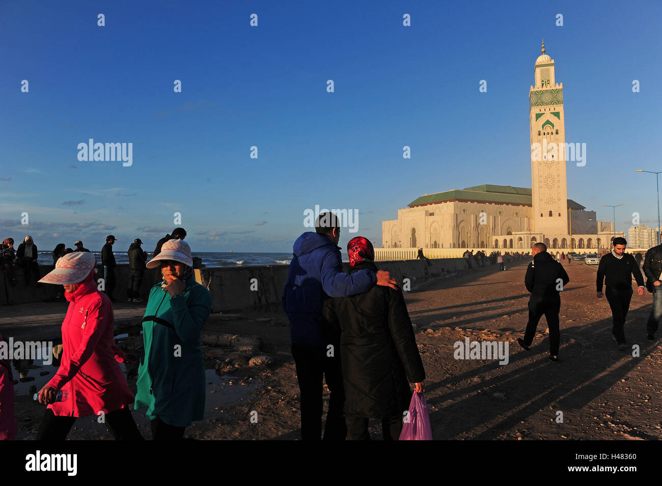 Les gens qui marchent par la Grande Mosquée Hassan II de Casablanca, la vue la plus impressionnante, achevée en 1994. Banque D'Images