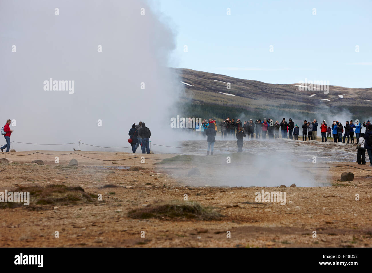 Les touristes restent là à regarder l'éruption du geyser strokkur geysir Islande Banque D'Images