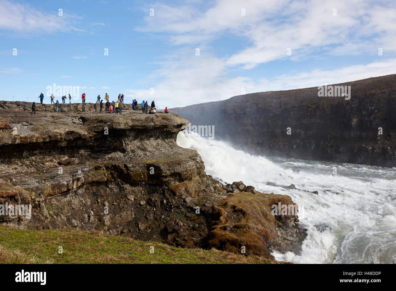 Les touristes sur la plate-forme de roche surplombant la cascade de Gullfoss dans le cercle d'or l'Islande Banque D'Images