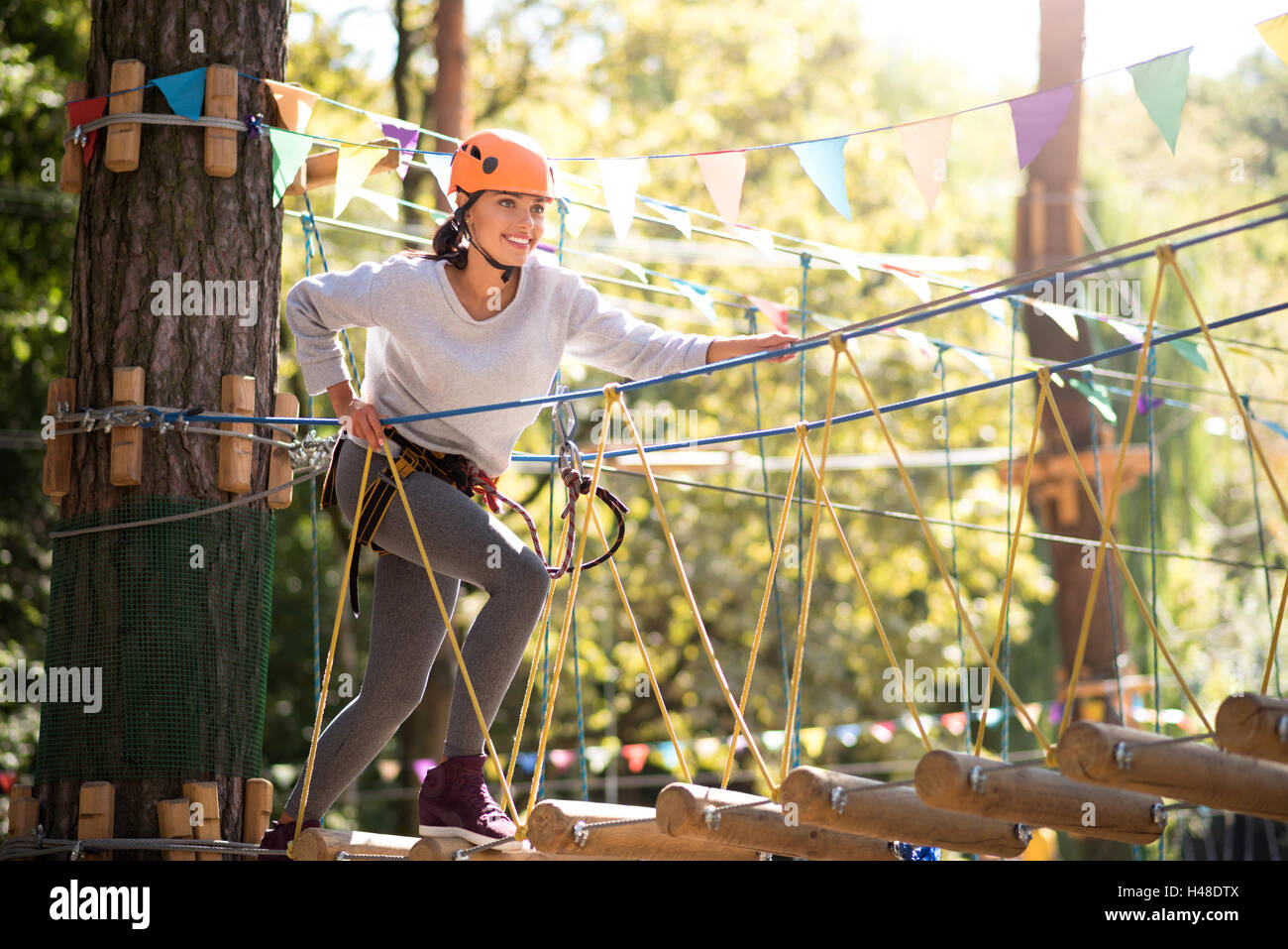 Heureux brave femme faisant un pas sur l'échelle de corde Banque D'Images