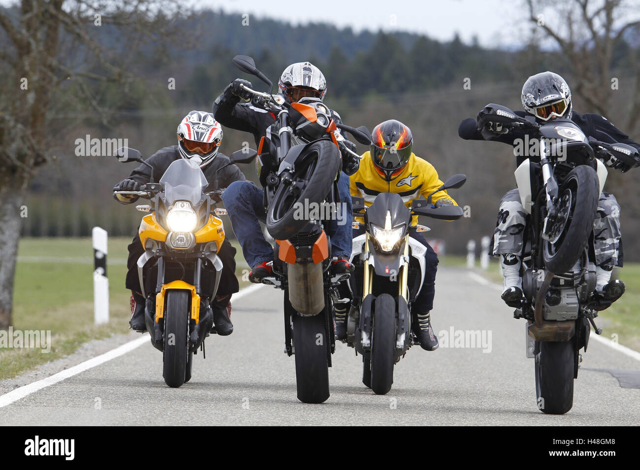 Motocycliste, quatre, moto, fun bikes, country road, Groupe moto, wheelie,  head-on Photo Stock - Alamy