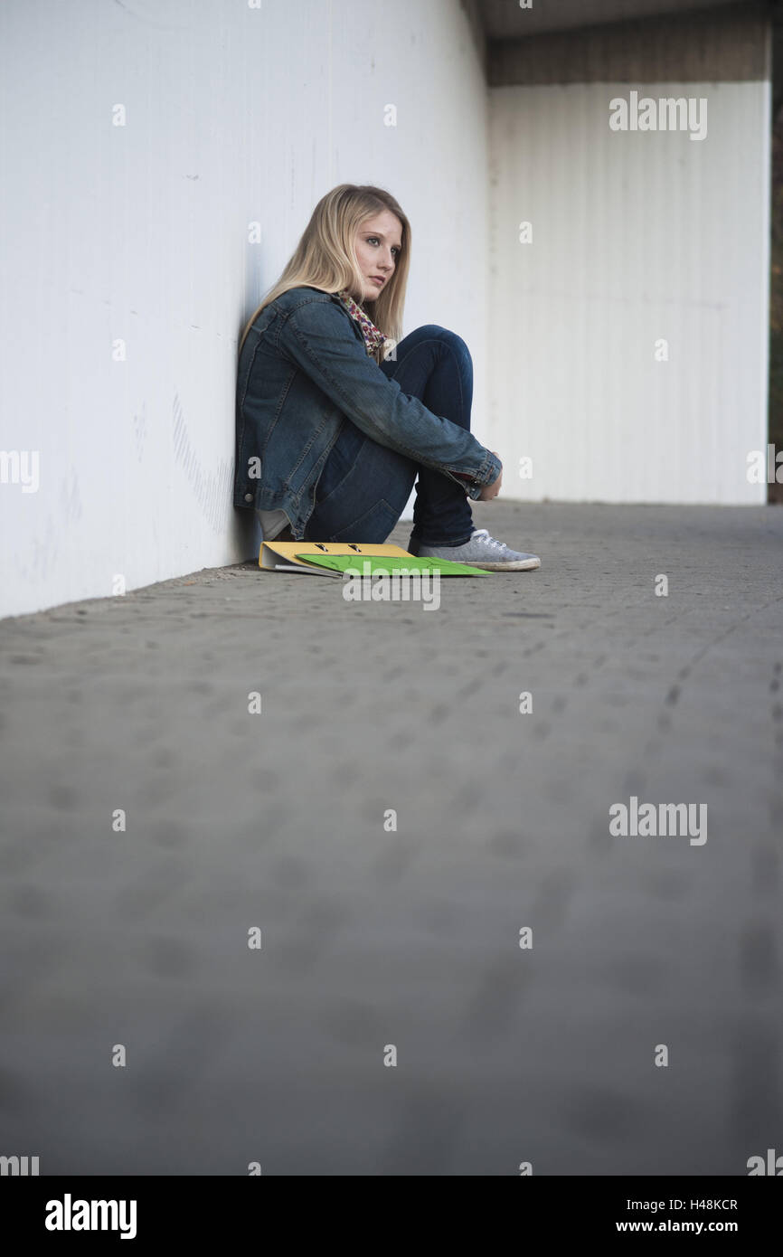 Jeune femme, est assis sur le plancher, mur, maigre, pense que, malheureusement, Banque D'Images