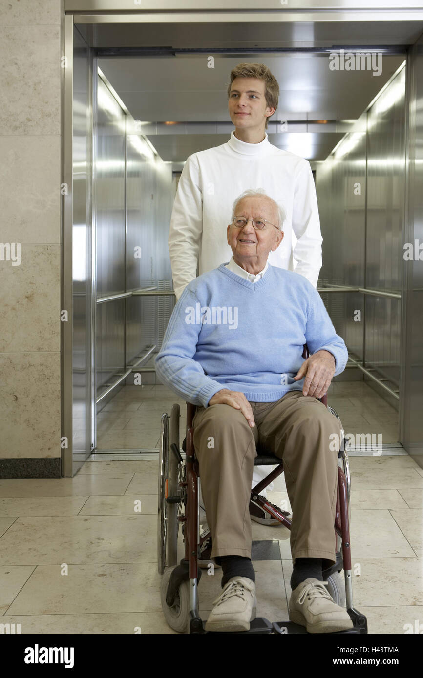 Ascenseur, patron, de l'invalide en fauteuil, s'asseoir, pousser l'Infirmière gériatrique, sourire, Banque D'Images