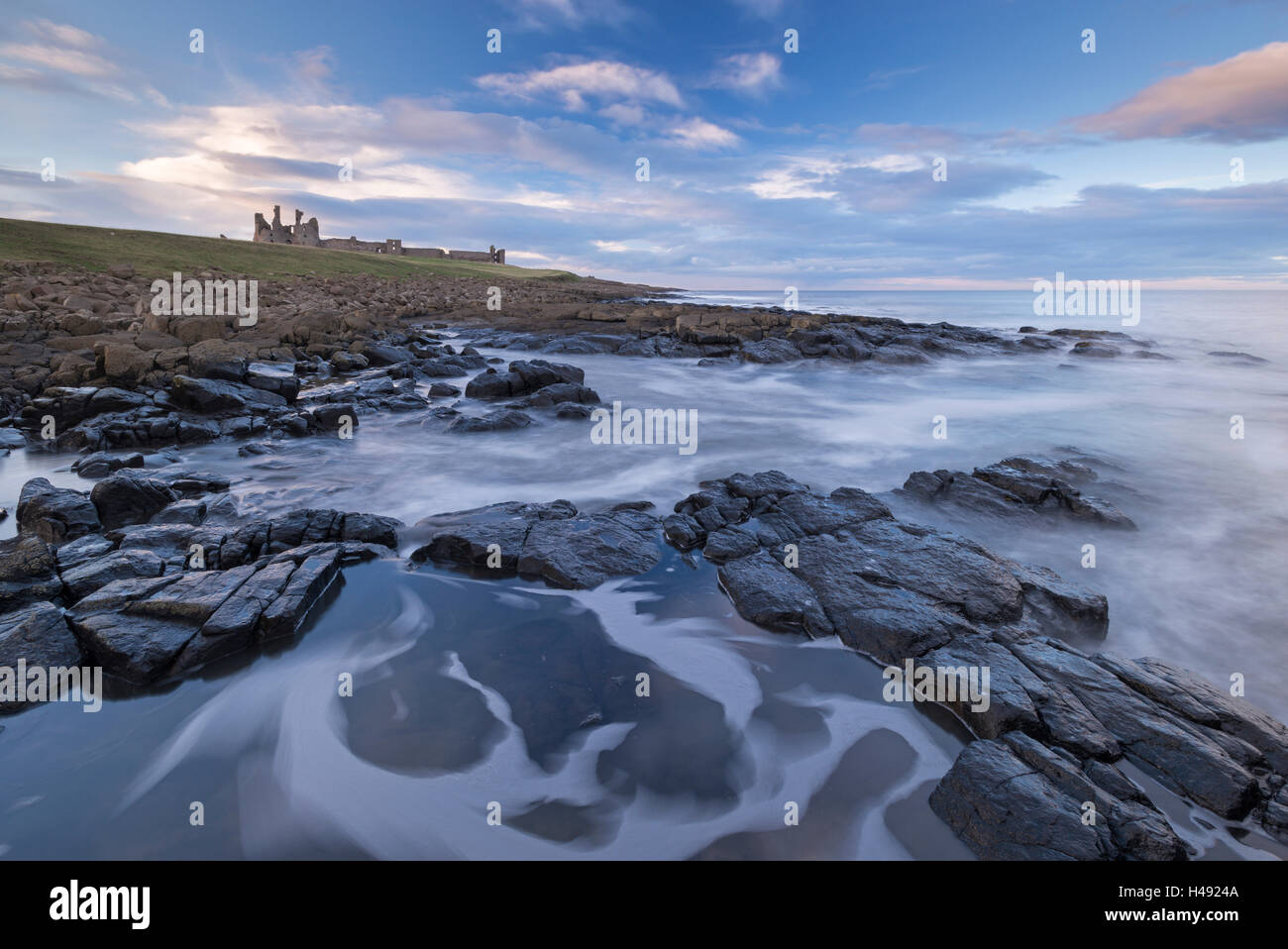 Les rivages rocheux ci-dessous château de Dunstanburgh, Craster, Northumberland, Angleterre. Printemps (mars) 2014. Banque D'Images